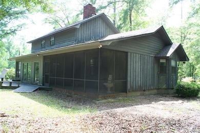 View of home's exterior with a chimney, a sunroom,