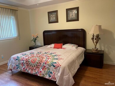 Bedroom with wood finished floors and crown molding