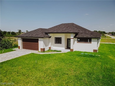 Prairie-style house featuring a front lawn, a gara