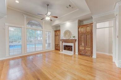Spacious family room featuring gas log fireplace, custom built-ins and gleaming hardwood flooors