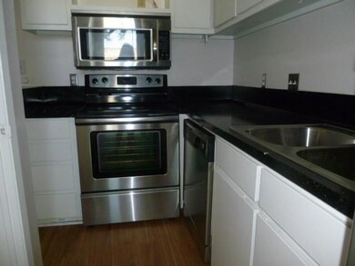 Kitchen featuring white cabinets, dark countertop
