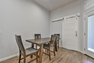 Dining space featuring a barn door and light wood-style floors