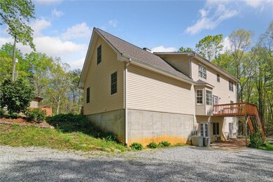 View of home's exterior with a deck, stairs, and driveway