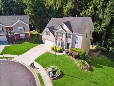 View of front of house featuring concrete driveway, an attached garage, a front lawn, and brick siding