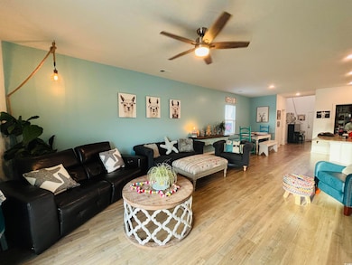 Living area featuring visible vents, light wood-ty