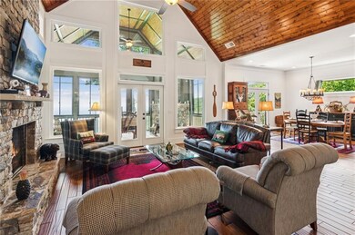 Living area featuring ceiling fan, high vaulted ceiling, a fireplace, hardwood / wood-style floors, and wooden ceiling