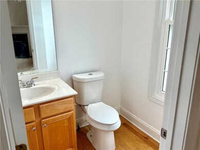 Guest Powder Room at the front of home with hardwood flooring and natural lighting from window.