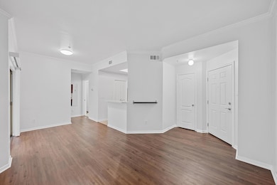 Spare room with baseboards, crown molding, visibl