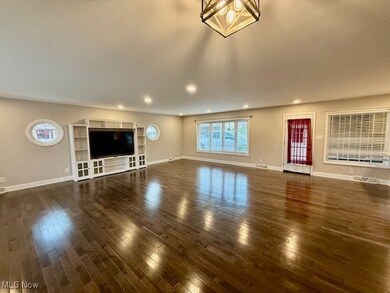 Unfurnished living room with dark wood-type flooring and recessed lighting