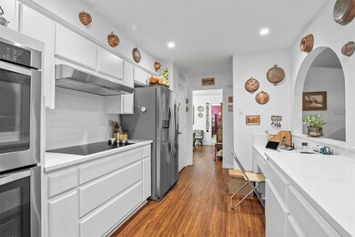 Kitchen with backsplash, wall chimney range hood, 