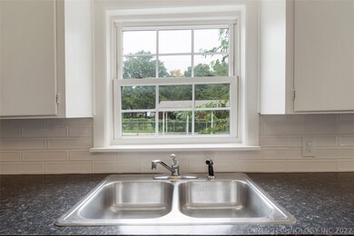 Window over sink overlooks large backyard.