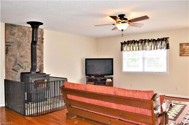 Living Room:  Wood Flooring, Ceiling Fan, Exterior Door leads to Large Deck, Wood Burning Wood-stove