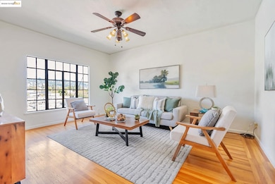 Living area with light wood-style floors and ceiling fan