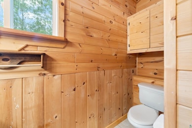 Bathroom with wood walls and toilet