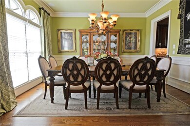 The formal dining room is perfect for entertaining guests and is accented with wainscoting, arched windows and custom trim and moldings