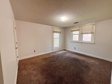 Unfurnished room featuring a textured ceiling, dar