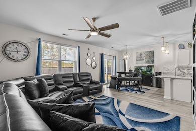 Living room with ceiling fan and light wood-style floors