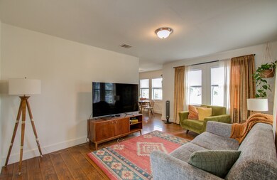 This bright and cozy living room lets in plenty of natural light. It leads to the breakfast and kitchen area giving an open feel. 