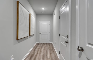 Hall featuring light wood finished floors and baseboards