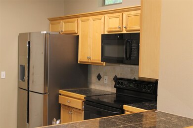 Kitchen with black appliances, tasteful backsplas