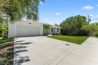 View of front of property featuring concrete driveway, a front yard, stucco siding, an attached garage, and metal roof