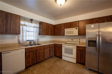 Kitchen featuring white appliances, a sink, light