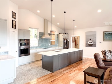 Open door at the far end of the island is the hallway to the utility room and attached 2 car garage.