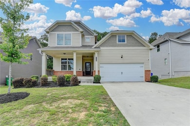 Craftsman inspired home with brick siding, covered porch, a front yard, and concrete driveway
