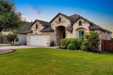 French provincial home with stone siding, drivewa