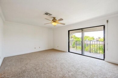 Empty room featuring carpet, crown molding, and a ceiling fan