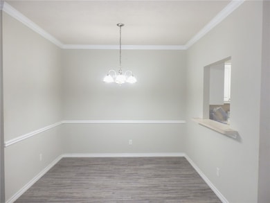 Unfurnished room with wood finished floors, crown