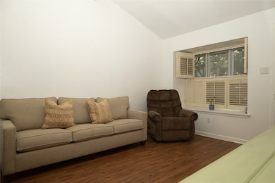 Living room with dark wood-style floors and lofted ceiling