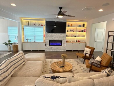 Living area with wood finished floors, a ceiling fan, recessed lighting, and a fireplace