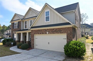 View of front facade featuring board and batten siding, driveway, and brick siding