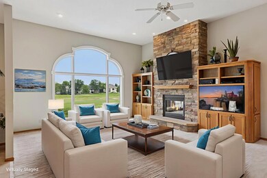 The elegant living room features custom built-ins framing a large TV system that stays, and a cozy gas fireplace. A massive six-pane window  offers a breathtaking view of Hole 8 of the TPC golf course! *Virtually staged to show design options!
