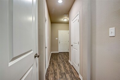Hall with dark wood-style floors and baseboards