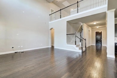 Unfurnished living room with arched walkways, a h