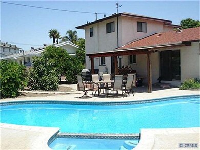 Back View of house with block wall and fruit trees.