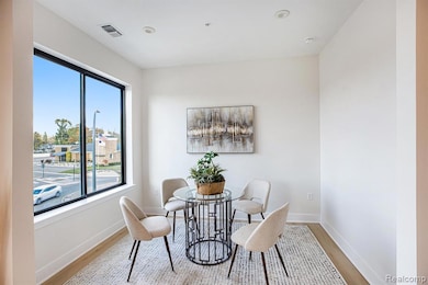 Living room featuring a tray ceiling, recessed lighting, and light wood finished floors