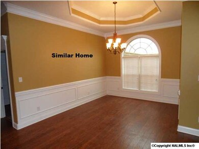 Large dining room with 10 foot ceiling, wood floor, shadow box and chair rail.