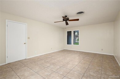Main Spacious Bedroom featuring a textured ceiling, light tile patterned floors, and ceiling fan