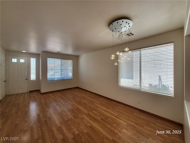 Foyer with wood finished floors, a chandelier, and