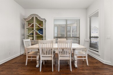 Dining room with dark wood-style floors and basebo