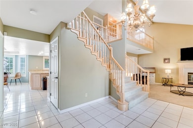 Stairs with a glass covered fireplace, tile patterned floors, a chandelier, a towering ceiling, and carpet