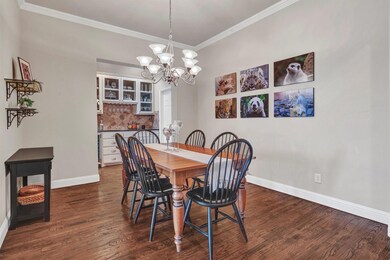 Dining room boasts hardwood flooring, crown mouldi