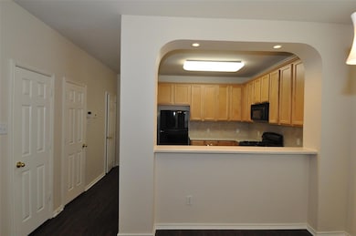 Kitchen with light countertops, arched walkways, 