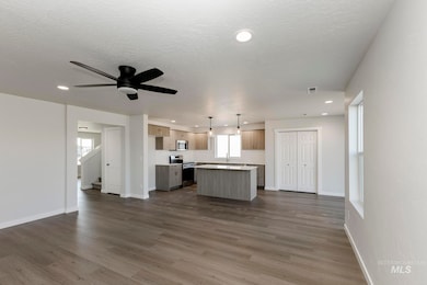 Kitchen featuring open floor plan, a center island, light countertops, recessed lighting, and stainless steel appliances
