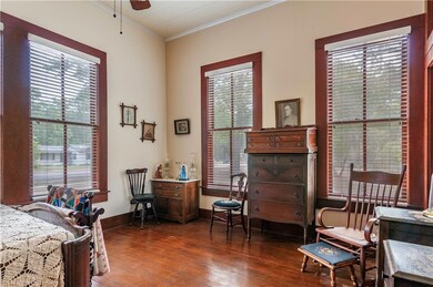 Bedroom with wood flooring and walls of windows.