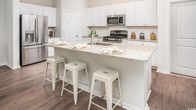 Kitchen featuring a sink, stainless steel appliances, a breakfast bar area, and white cabinets