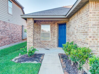 Covered front porch has room for a rocking chair and flower pots.